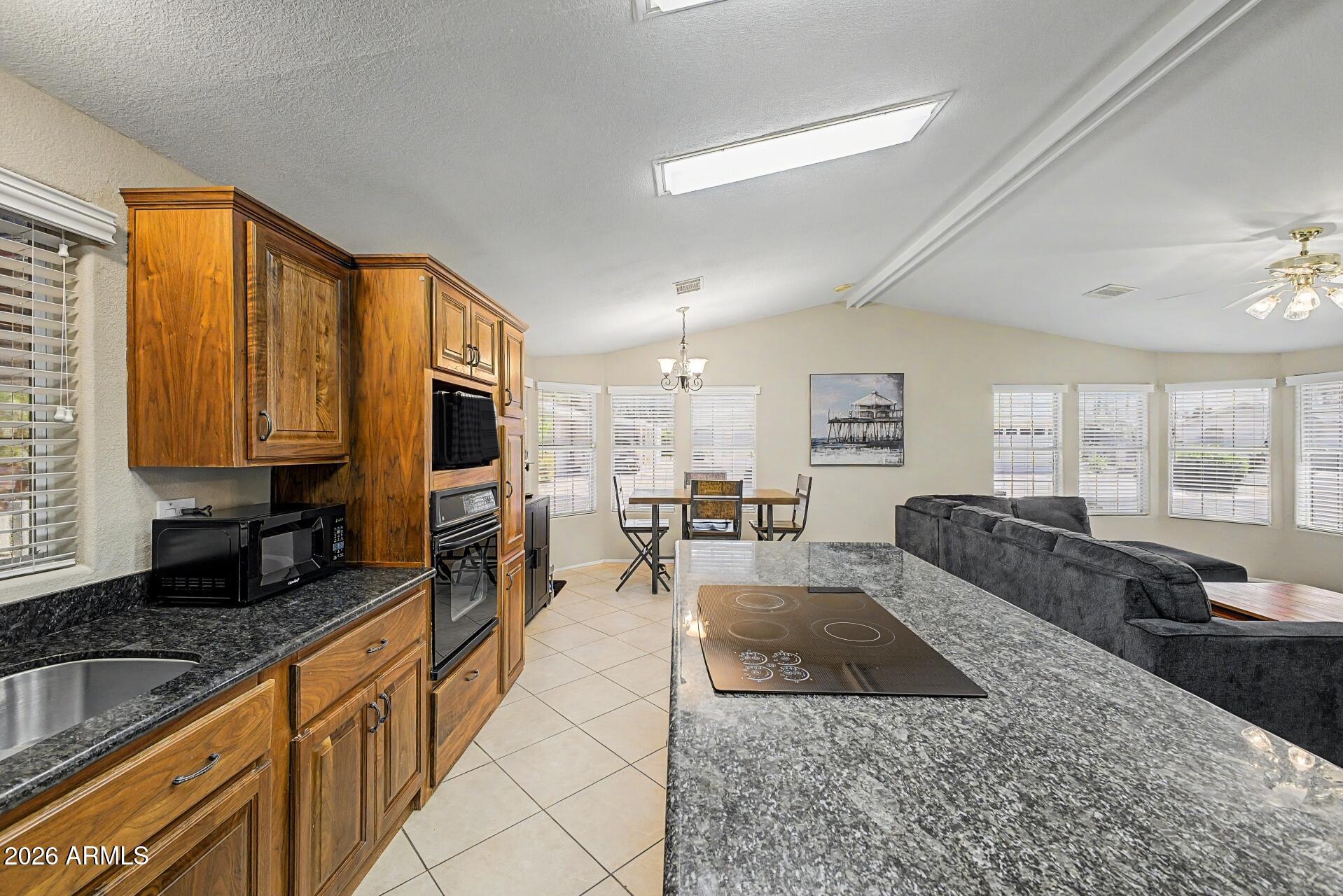 2550 South Ellsworth Road, Unit 46 Mesa, AZ 85209 - Photo 5 of 47 a large living room with stainless steel appliances granite countertop a couch a dining table and a chandelier
