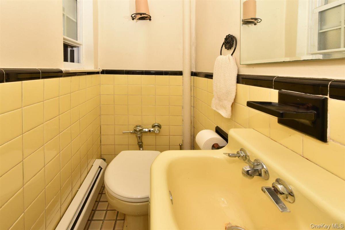 139-30 Coolidge Avenue Queens, NY 11435 - Photo 11 of 34 Bathroom with tile walls, baseboard heating, tile patterned floors, and a wainscoted wall