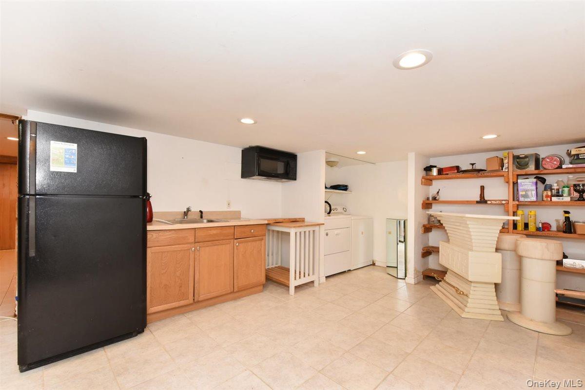 139-30 Coolidge Avenue Queens, NY 11435 - Photo 22 of 34 Kitchen with black appliances, light countertops, recessed lighting, and washing machine and dryer