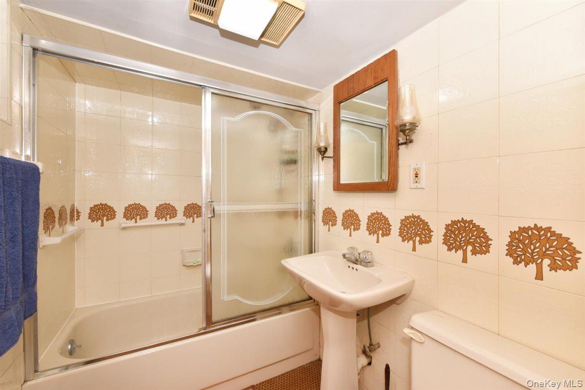 139-30 Coolidge Avenue Queens, NY 11435 - Photo 23 of 34 Bathroom featuring enclosed tub / shower combo and tile walls