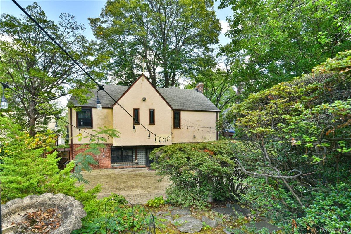 139-30 Coolidge Avenue Queens, NY 11435 - Photo 25 of 34 Rear view of property with stucco siding, brick siding, view of wooded area, a chimney, and roof with shingles