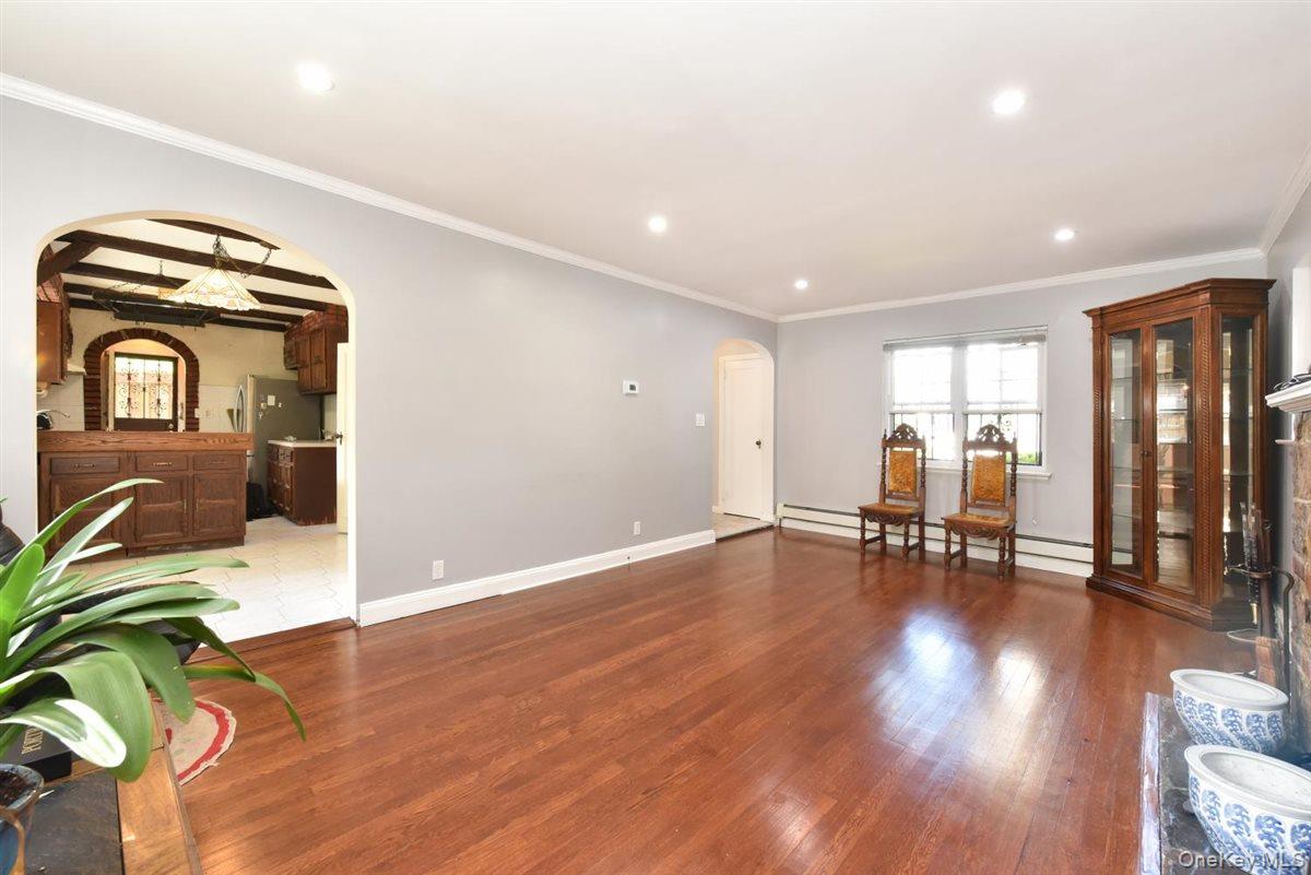 139-30 Coolidge Avenue Queens, NY 11435 - Photo 5 of 34 Living area with arched walkways, wood finished floors, ornamental molding, recessed lighting, and beamed ceiling