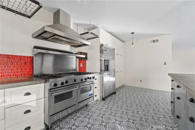 a kitchen with granite countertop a sink a counter space appliances and cabinets