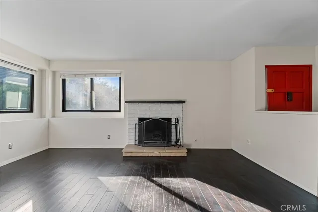 an empty room with floor to ceiling window and fireplace