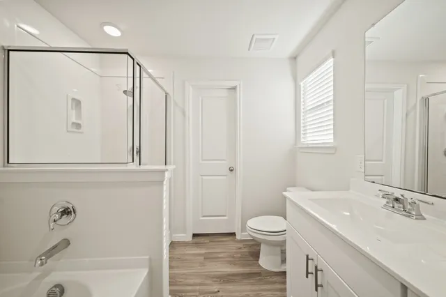a bathroom with a sink a toilet and a large mirror