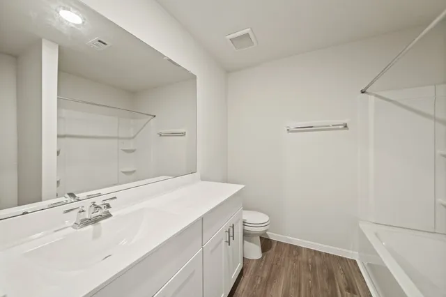 a bathroom with a sink a toilet and a shower