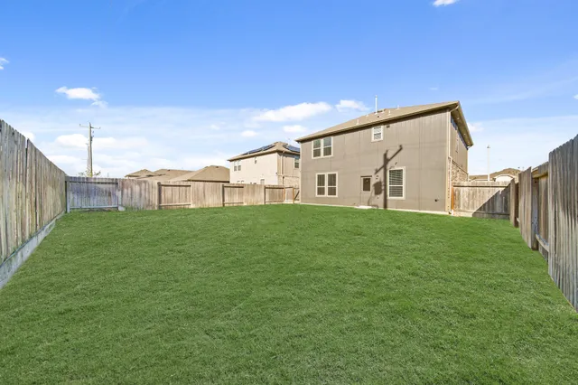 a view of a house with backyard and porch