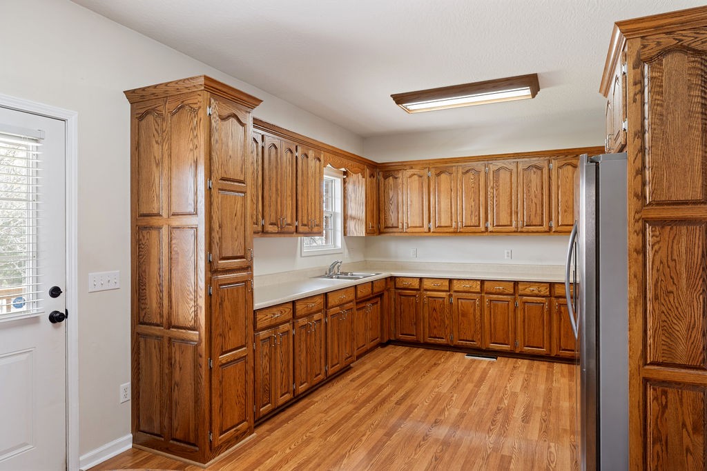 137 Piney Road Lawrenceburg, TN 38464 - Photo 12 of 33 a kitchen with stainless steel appliances granite countertop a refrigerator a sink dishwasher a stove and white countertops with wooden floor