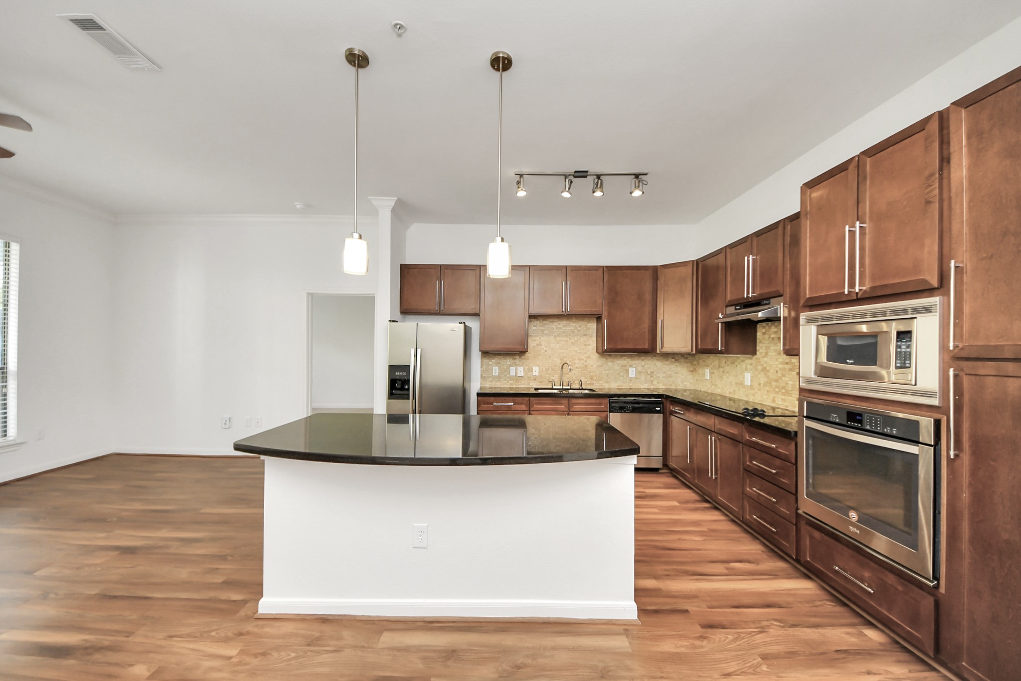 a large kitchen with stainless steel appliances granite countertop a stove a sink and a refrigerator