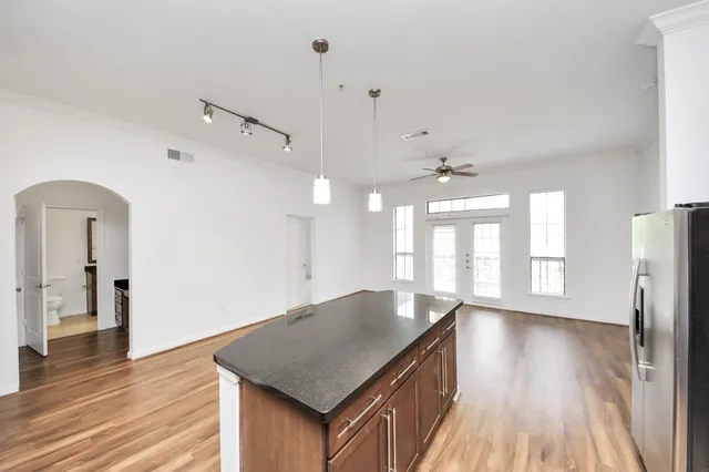 a kitchen with kitchen island granite countertop a sink stove and cabinets
