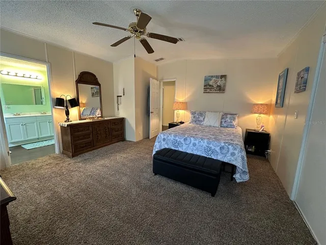 a spacious bedroom with a bed and a flat screen tv