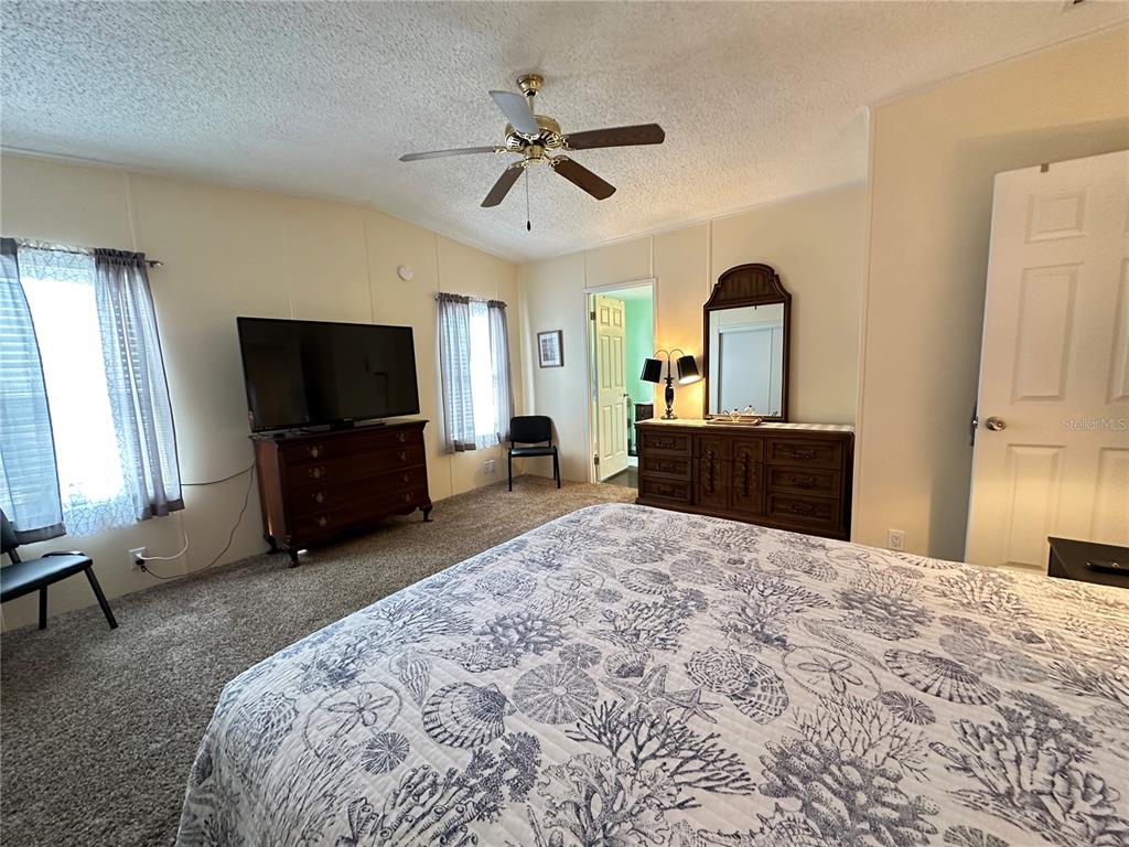16735 Olivaud Street Hudson, FL 34667 - Photo 33 of 53 a spacious bedroom with a bed and a flat screen tv