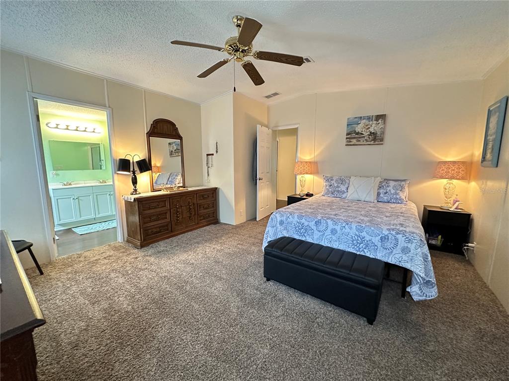 16735 Olivaud Street Hudson, FL 34667 - Photo 37 of 53 a spacious bedroom with a bed and a chandelier