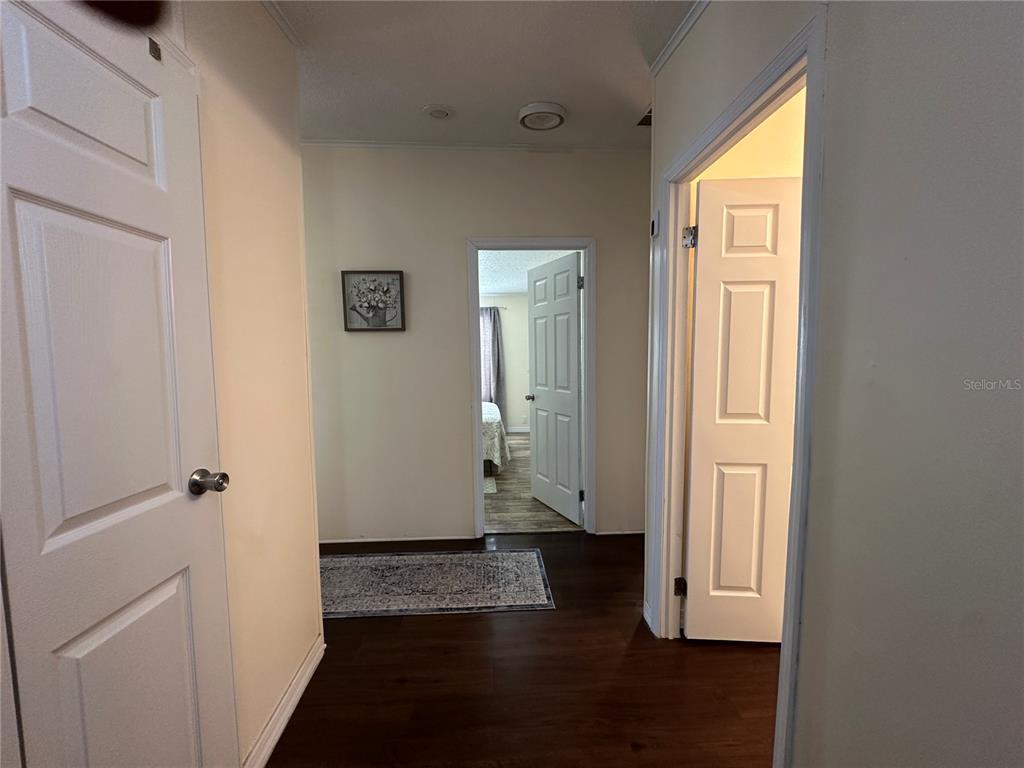 16735 Olivaud Street Hudson, FL 34667 - Photo 44 of 53 a view of a hallway with wooden floor and a cabinet