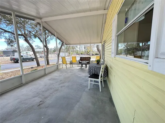 a view of a porch with furniture and a yard