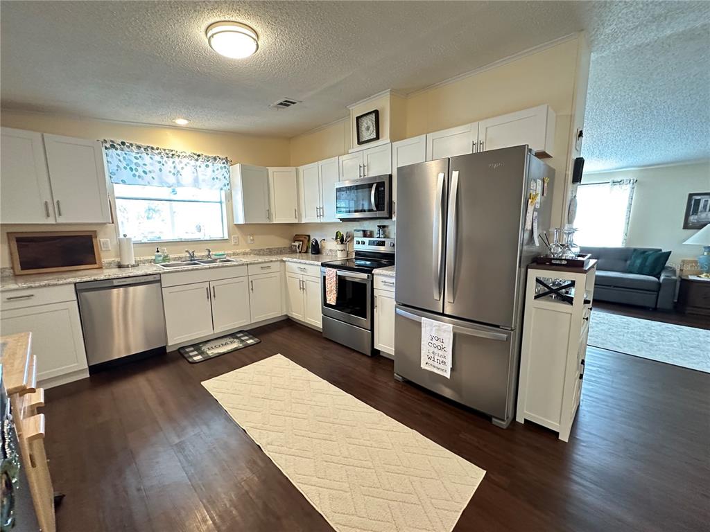 16735 Olivaud Street Hudson, FL 34667 - Photo 10 of 53 a kitchen with stainless steel appliances a refrigerator sink and wooden floor