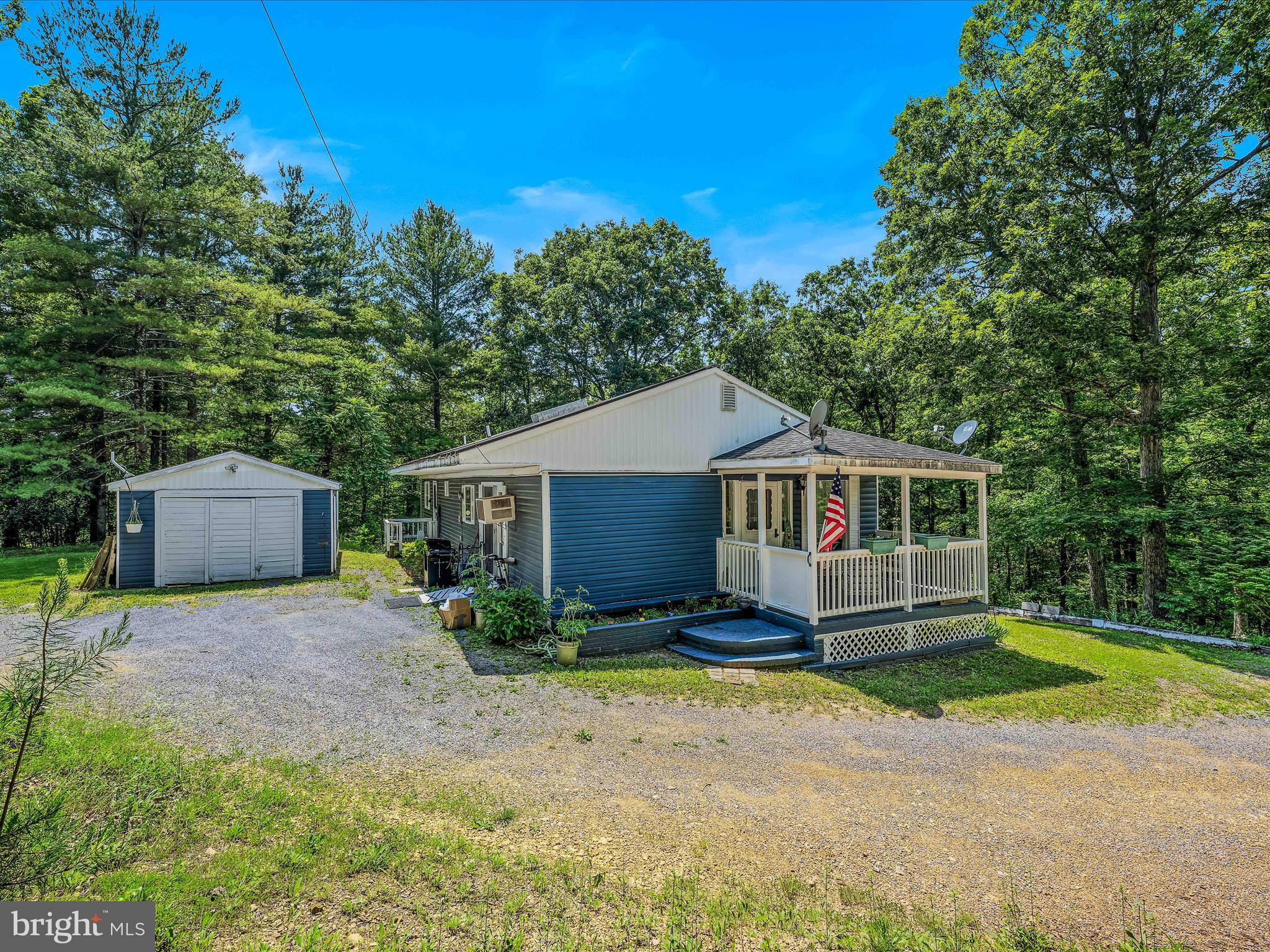 378 Oak Hill Road Berkeley Springs, WV 25411 - Photo 1 of 57 a front view of a house with garden