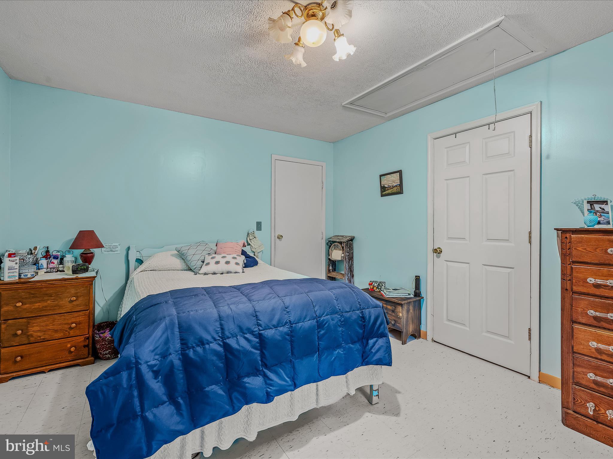 378 Oak Hill Road Berkeley Springs, WV 25411 - Photo 14 of 57 a bedroom with a bed and a chandelier