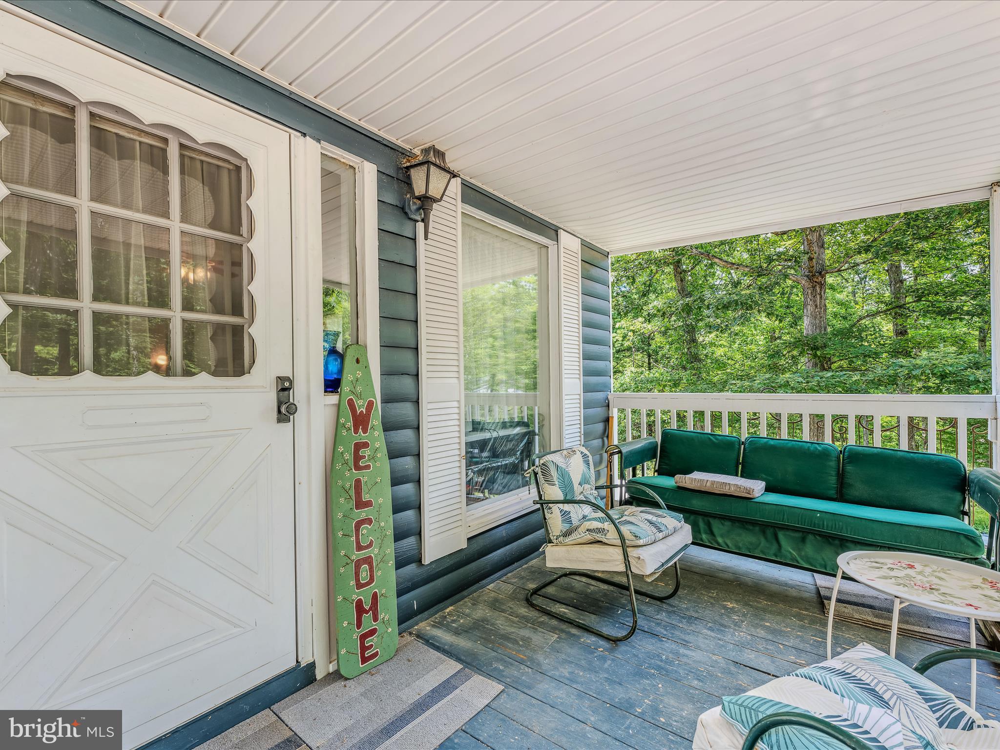 378 Oak Hill Road Berkeley Springs, WV 25411 - Photo 4 of 57 a balcony with couple of chairs and a wooden floor
