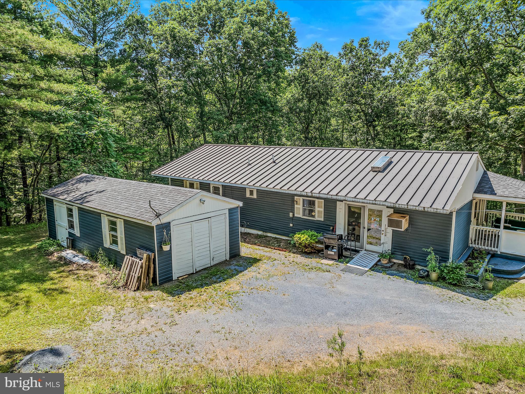 378 Oak Hill Road Berkeley Springs, WV 25411 - Photo 50 of 57 a front view of a house with a garden and sitting area
