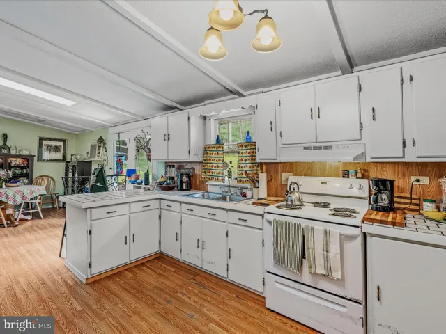 a kitchen with cabinets stainless steel appliances and wooden floor
