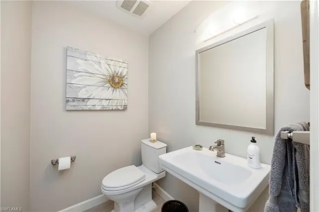 a bathroom with a sink mirror and toilet