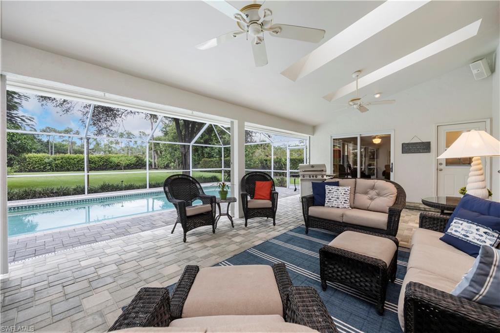 5520 Cynthia Lane Naples, FL 34112 - Photo 20 of 32 a living room with furniture and a floor to ceiling window
