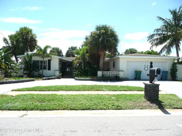 a front view of a house with a yard and potted plants