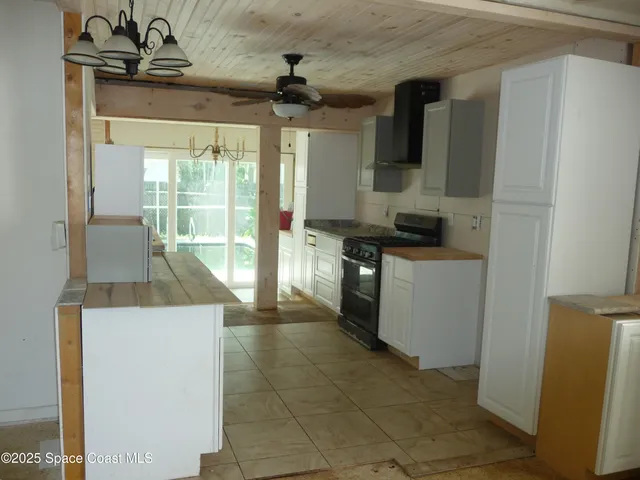 a kitchen with a sink a stove top oven and cabinets