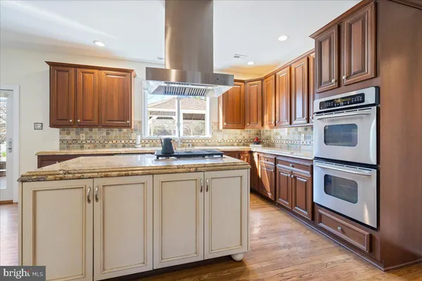 a kitchen with stainless steel appliances granite countertop a stove a sink dishwasher and a microwave oven with wooden cabinets