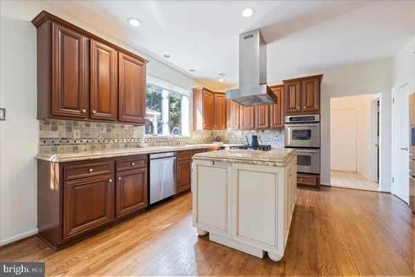 a kitchen with a sink cabinets stainless steel appliances and a window