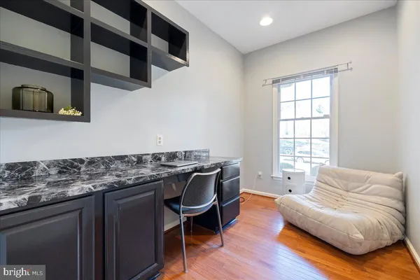 a living room with stainless steel appliances granite countertop furniture wooden floor and a window
