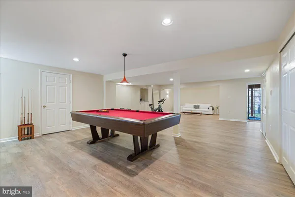 a room with pool table and wooden floor
