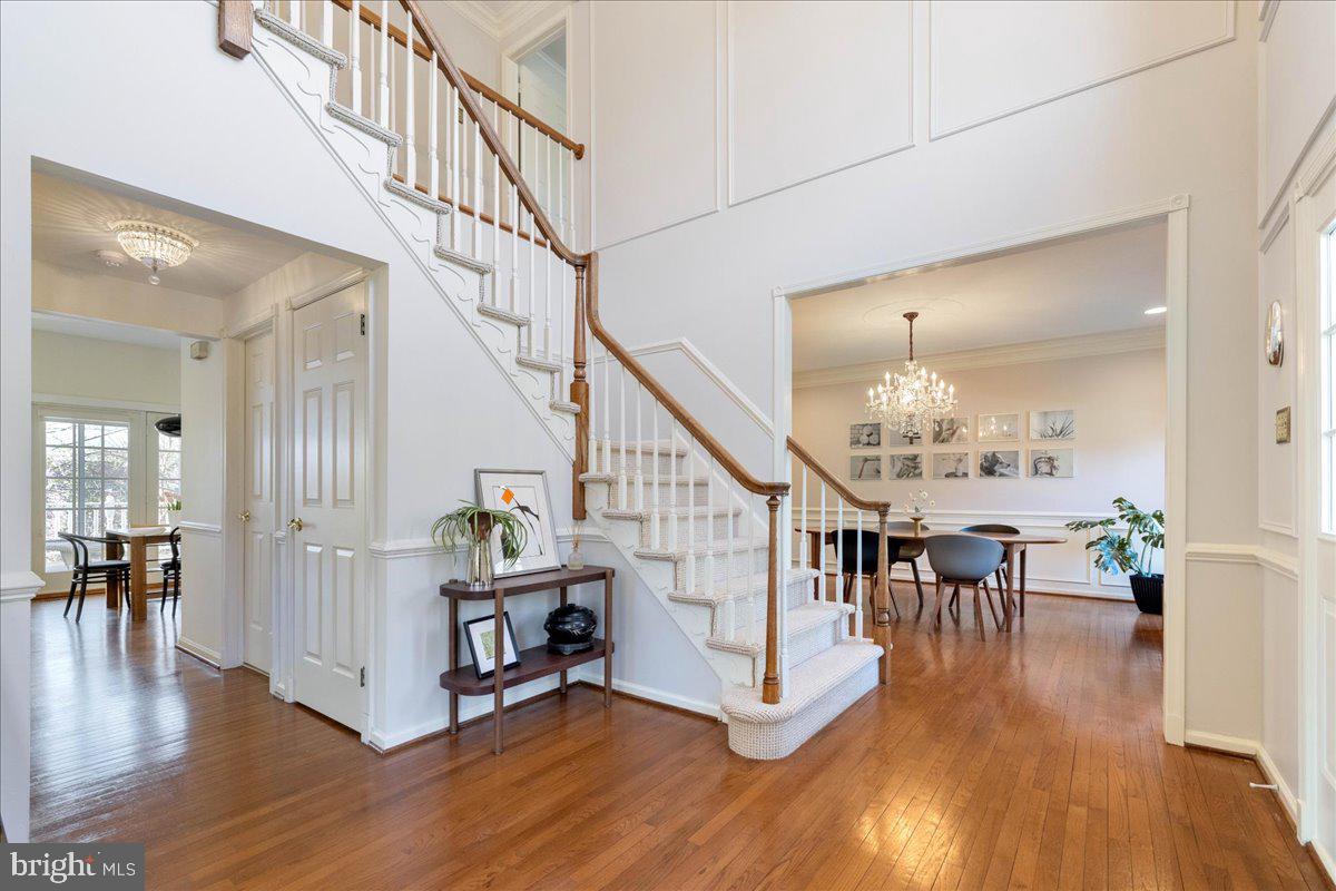 1488 Heather Ridge Drive Newtown, PA 18940 - Photo 6 of 46 a view of staircase and dining room with wooden floor and a chandelier
