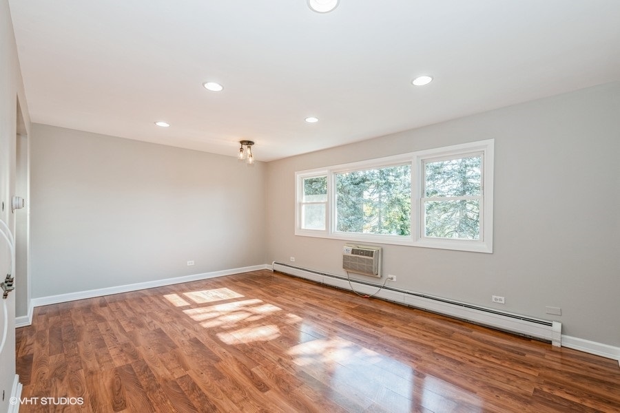8811 Plainfield Road, Unit 7 Brookfield, IL 60513 - Photo 2 of 10 an empty room with wooden floor and windows