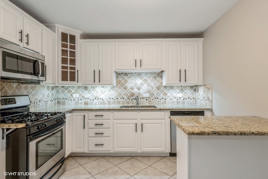 8811 Plainfield Road, Unit 7 Brookfield, IL 60513 - Photo 4 of 10 a kitchen with granite countertop white cabinets and stainless steel appliances