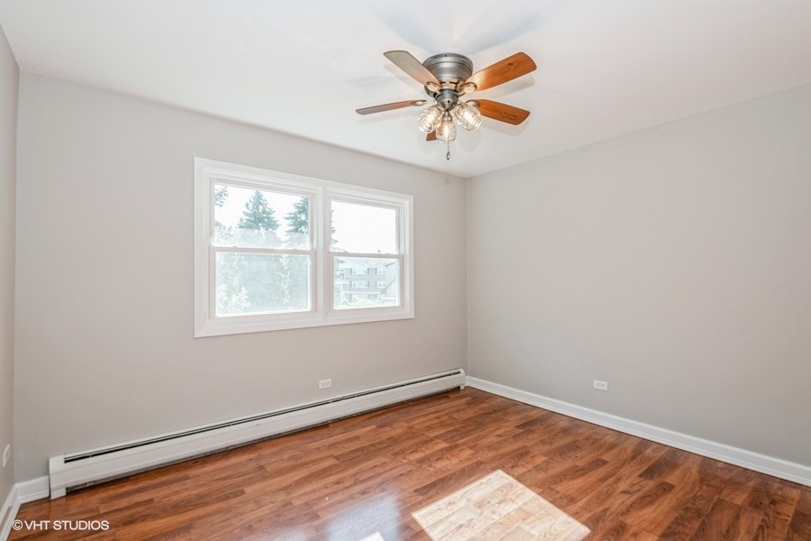 8811 Plainfield Road, Unit 7 Brookfield, IL 60513 - Photo 7 of 10 an empty room with wooden floor fan and windows