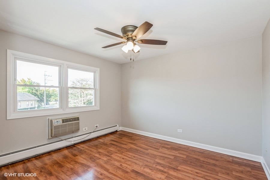 8811 Plainfield Road, Unit 7 Brookfield, IL 60513 - Photo 8 of 10 an empty room with wooden floor fan and windows