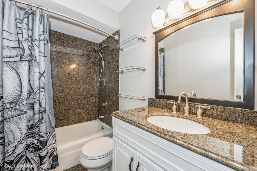8811 Plainfield Road, Unit 7 Brookfield, IL 60513 - Photo 9 of 10 a bathroom with a granite countertop sink toilet a mirror and shower