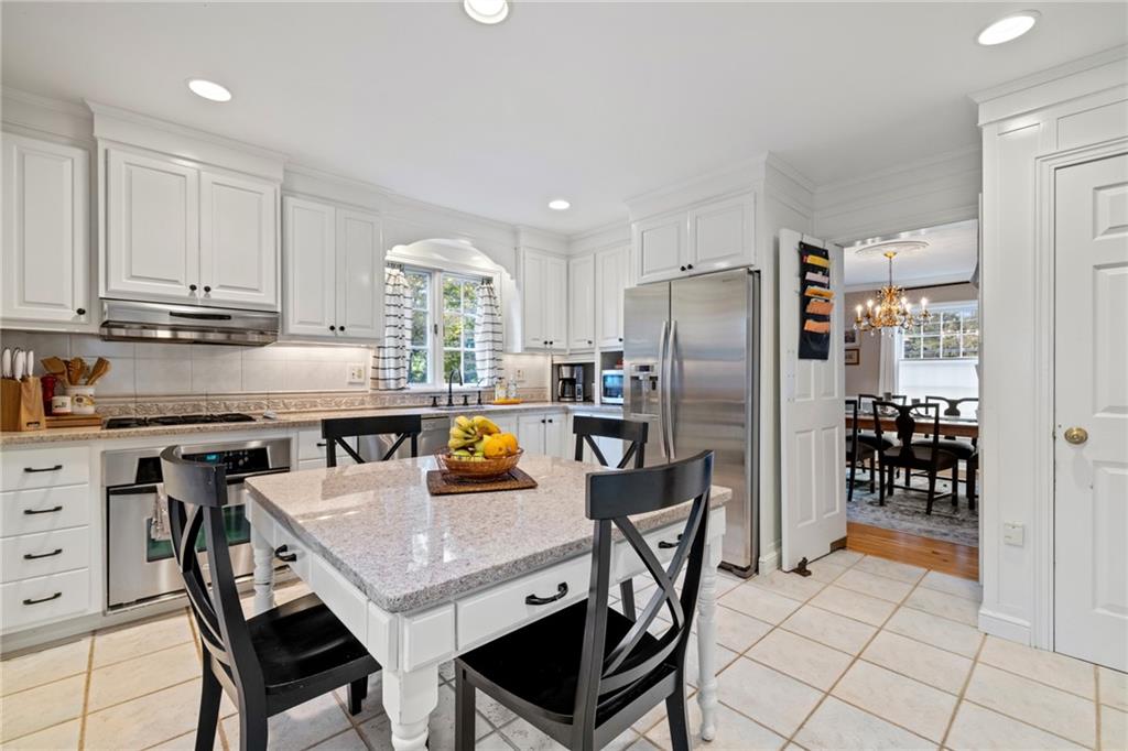 800 Hulton Road Oakmont, PA 15139 - Photo 9 of 25 a kitchen with stainless steel appliances granite countertop a stove a refrigerator a kitchen island and chairs in it