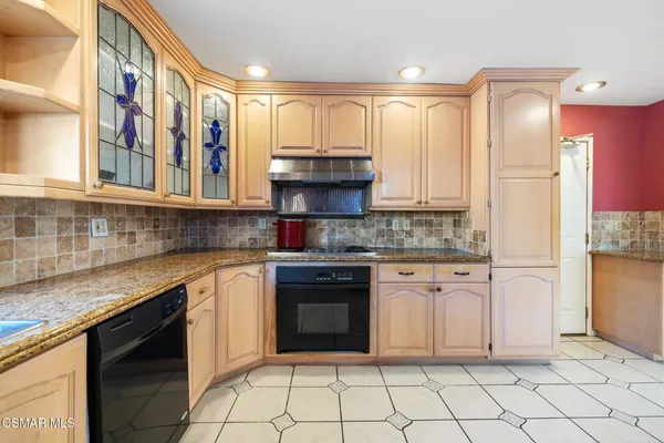 a kitchen with granite countertop white cabinets and stainless steel appliances