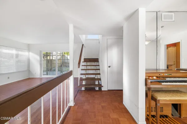 a view of a hallway with entryway and stairs