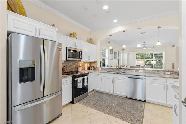 a kitchen with stainless steel appliances granite countertop a refrigerator a sink a stove a microwave and island