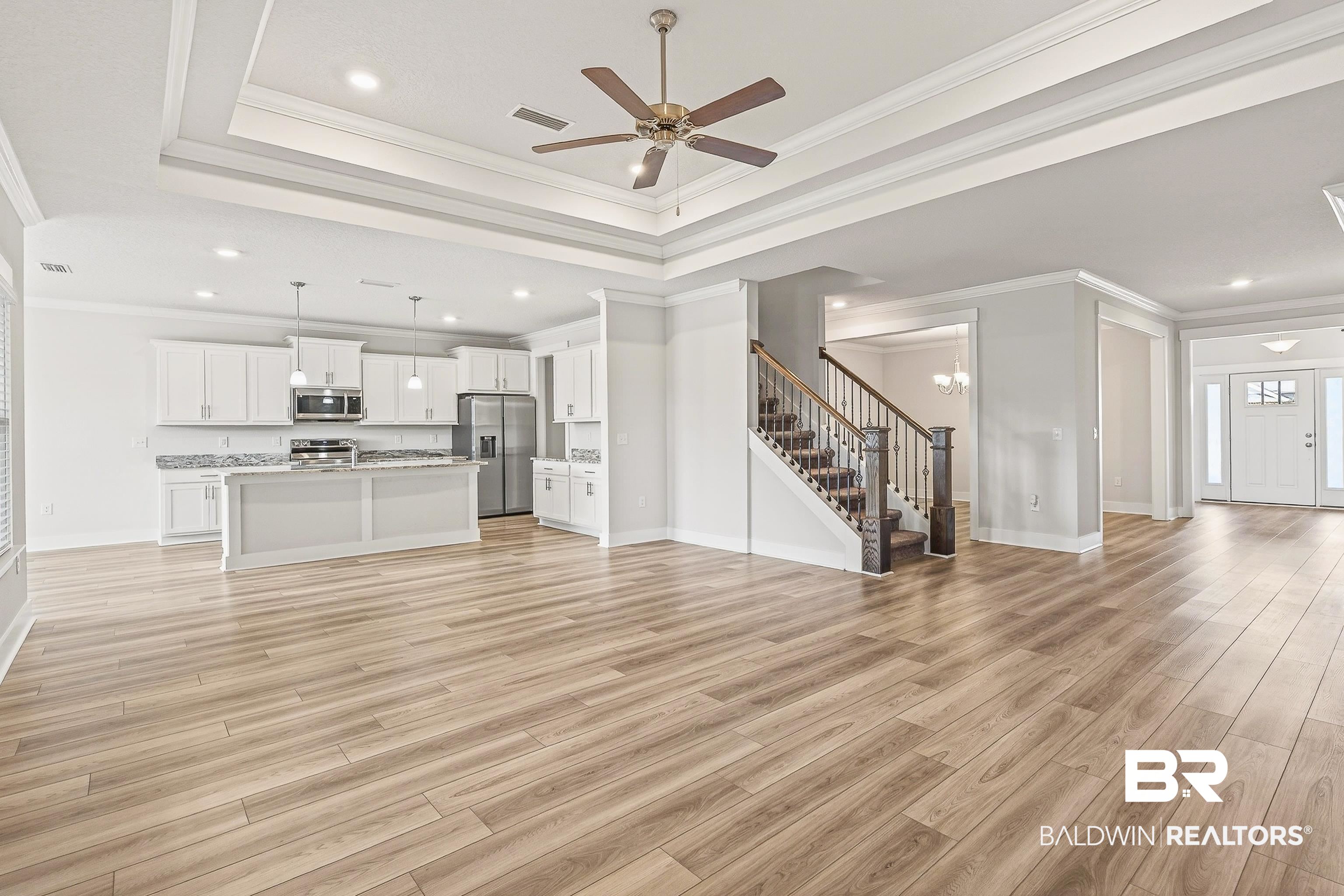 1728 Partridge Street Foley, AL 36535 - Photo 9 of 37 Unfurnished living room with a ceiling fan, light wood-style floors, recessed lighting, crown molding, and a tray ceiling