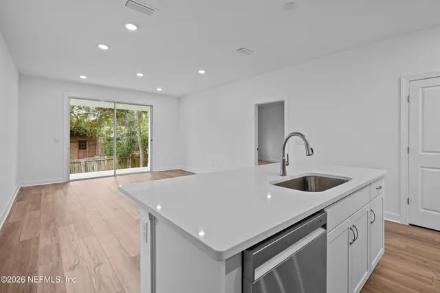 a kitchen with a sink and wooden floor