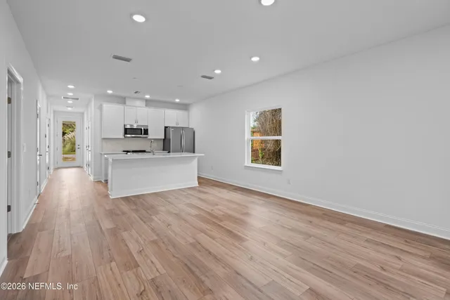 a view of kitchen with wooden floor and electronic appliances