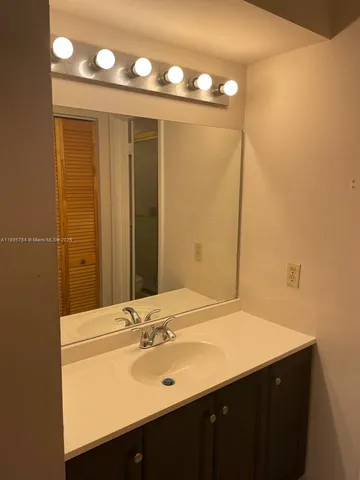 a bathroom with a sink vanity and a mirror