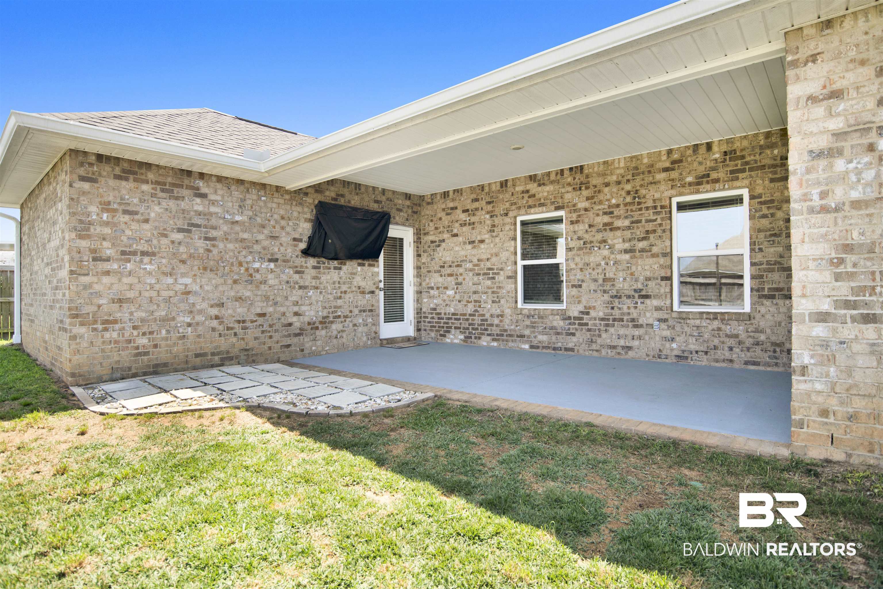 8493 Bronze Lane Foley, AL 36535 - Photo 31 of 38 Covered patio featuring brick exterior walls and a painted concrete floor
