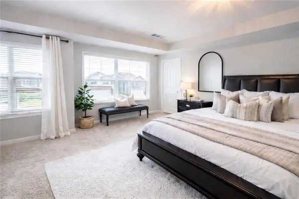 a spacious bedroom with bed and a window