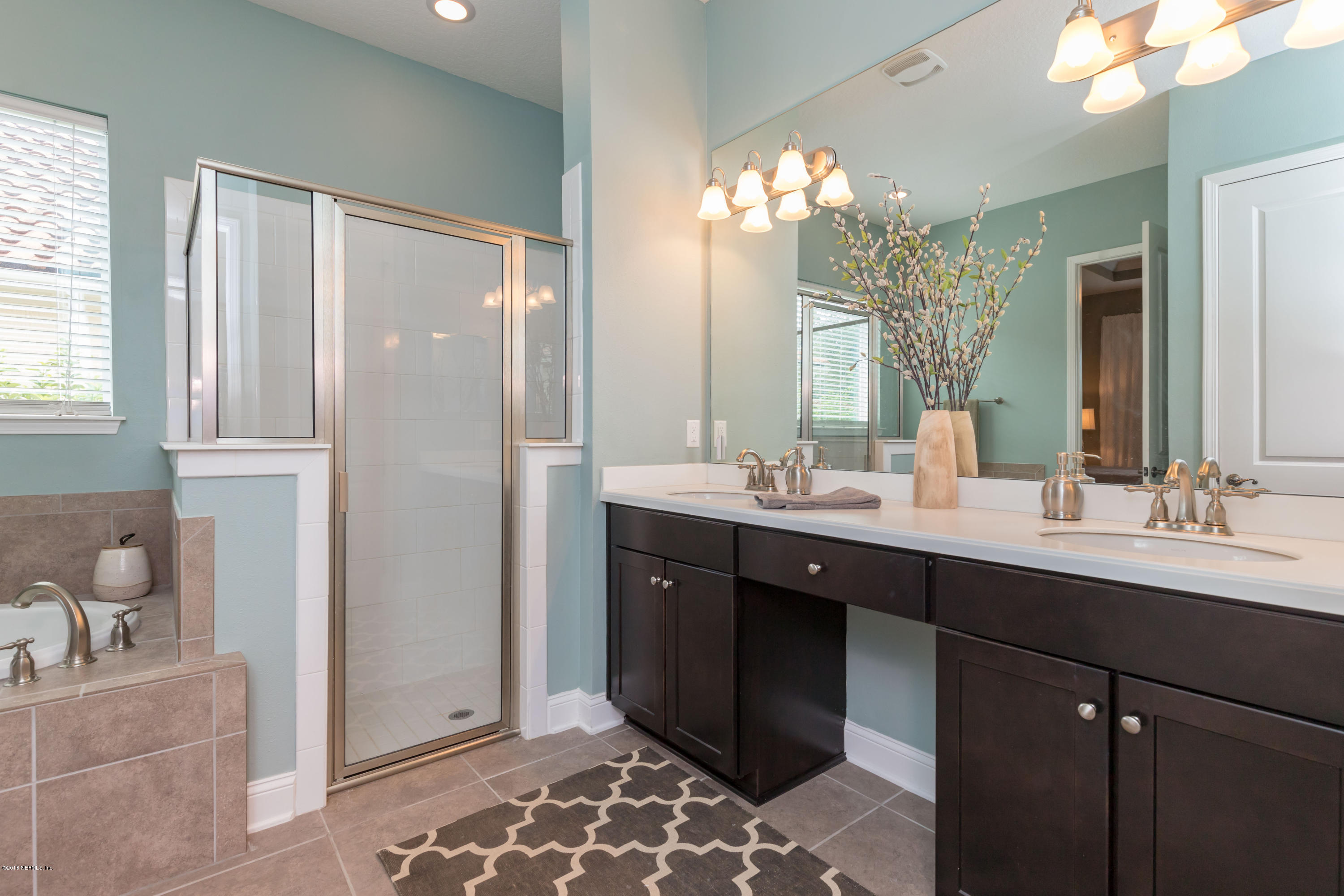 3811 Valverde Circle Jacksonville, FL 32224 - Photo 21 of 42 a bathroom with a double vanity sink a mirror and a shower